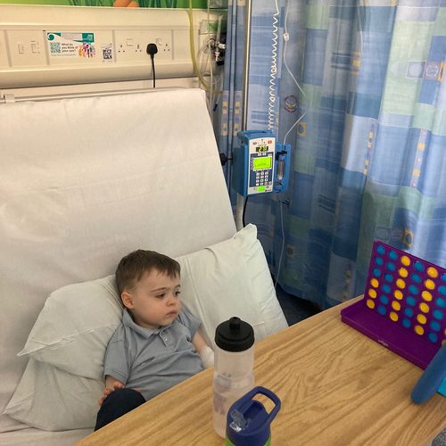 Freddie playing Connect 4 on a hospital tray table