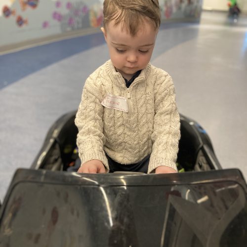 Freddie waiting at hospital reception with his name badge