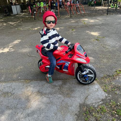 Freddie riding his toy motorbike, full of energy