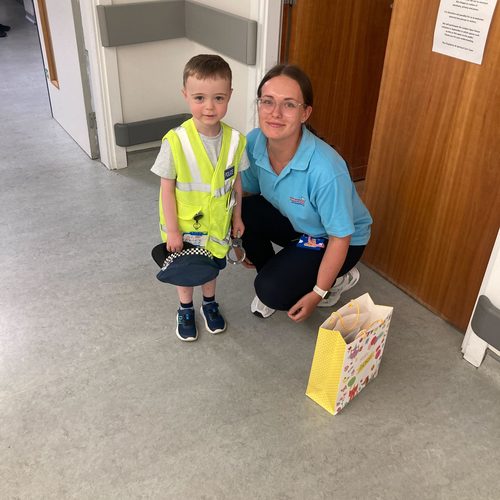Freddie in a police costume with a hospital staff member