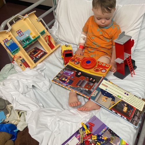 Freddie in his hospital bed surrounded by Fireman Sam toys