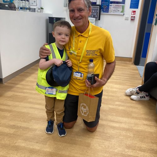 Freddie with a hospital volunteer holding a thank you gift bag