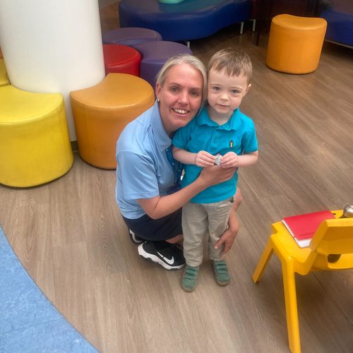 Freddie with a hospital staff member holding a small token
