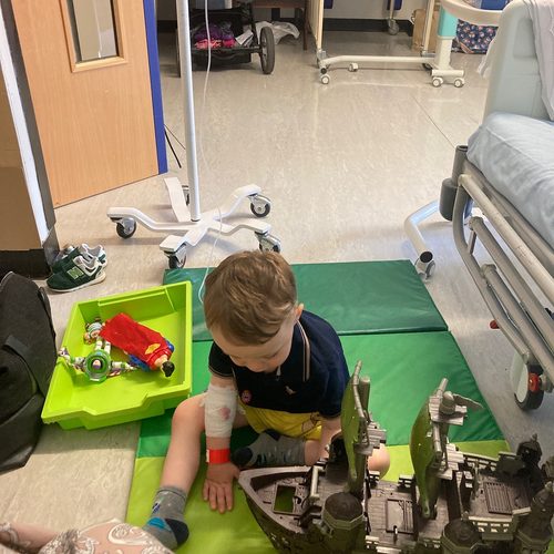 Freddie playing with a toy pirate ship, arm bandaged
